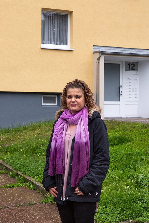 Dr. Marina Block Dr. Marina Block steht vor einem Plattenbau in Leipzig-Lößnig