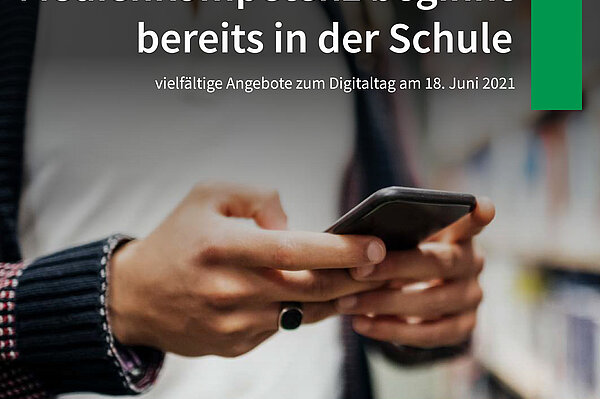 Digitaltag 2021 junger Mann hält vor einem Bücherregal ein Smartphone in der HandEin
